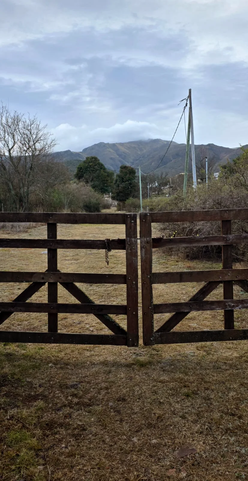 Tranquera de madera con las sierras de fondo